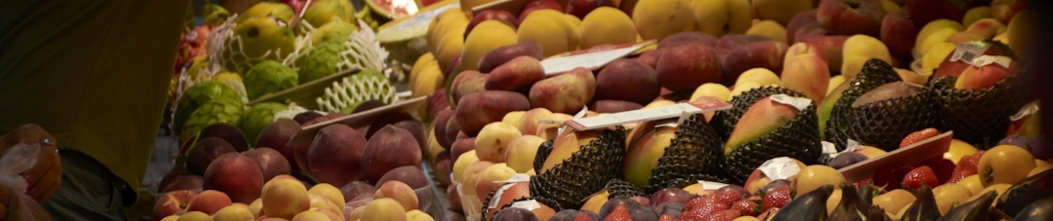A man standing in front of a display of fruit