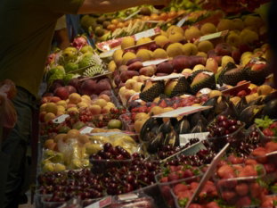 A man standing in front of a display of fruit